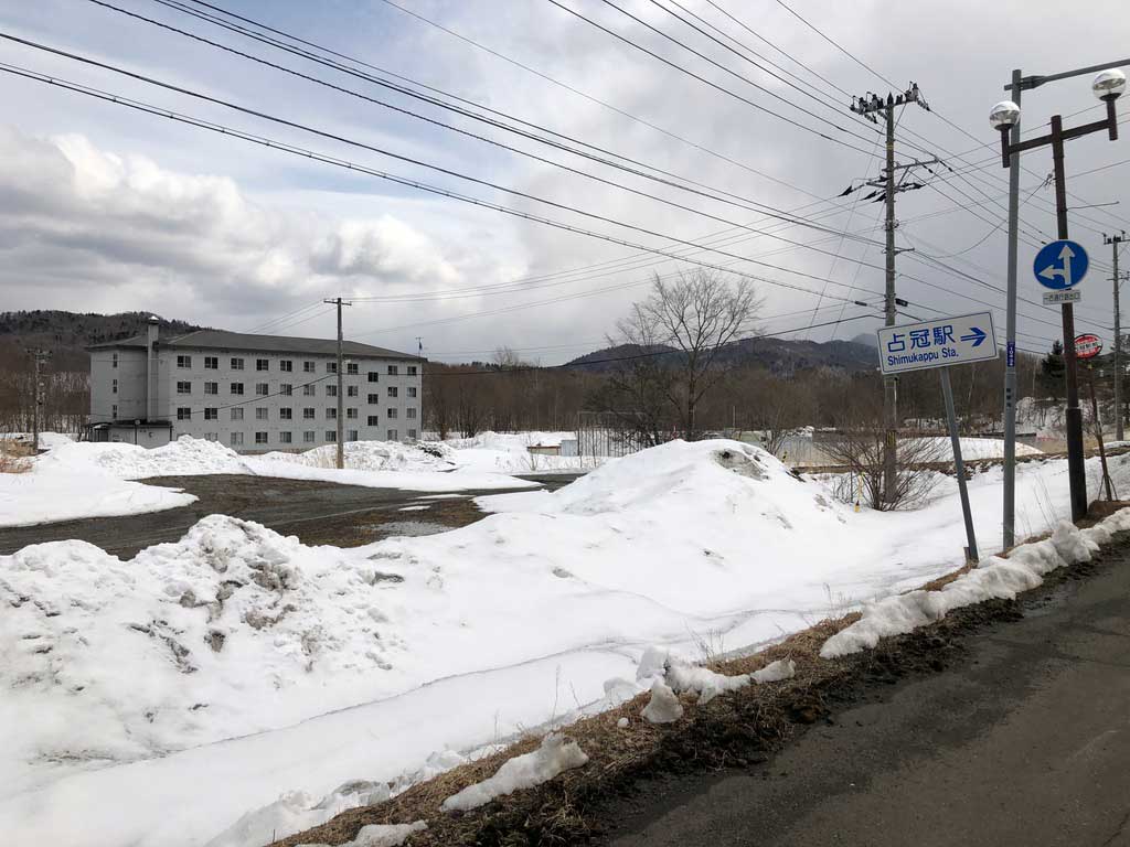 寮の建物と占冠駅への案内標識